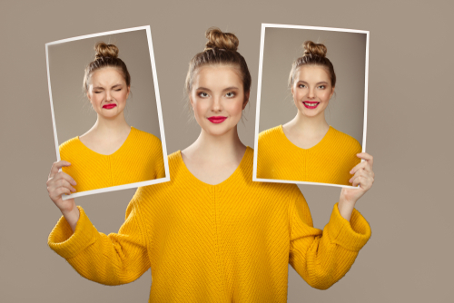 The girl holds and changes face with portraits with different emotions.