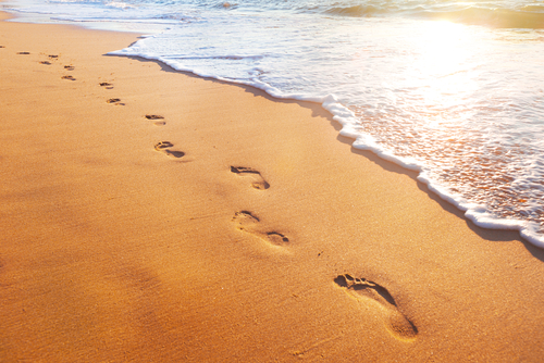 Beachb wave and footprints